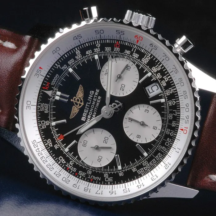 Gros plan sur les échelles de la règle à calcul d'une Breitling Navitimer, avec les repères MPH, KM, STAT et NAUT